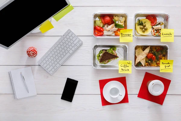 Healthy daily meals in office, top view at wood