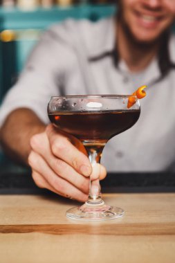 Genç barmen gece kulübü barda kokteylin alkol sunar