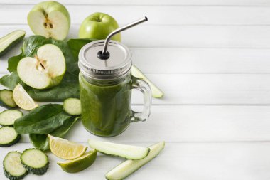 Beyaz ahşap zemin üzerinde doğal detoks yeşil smoothie maddeler