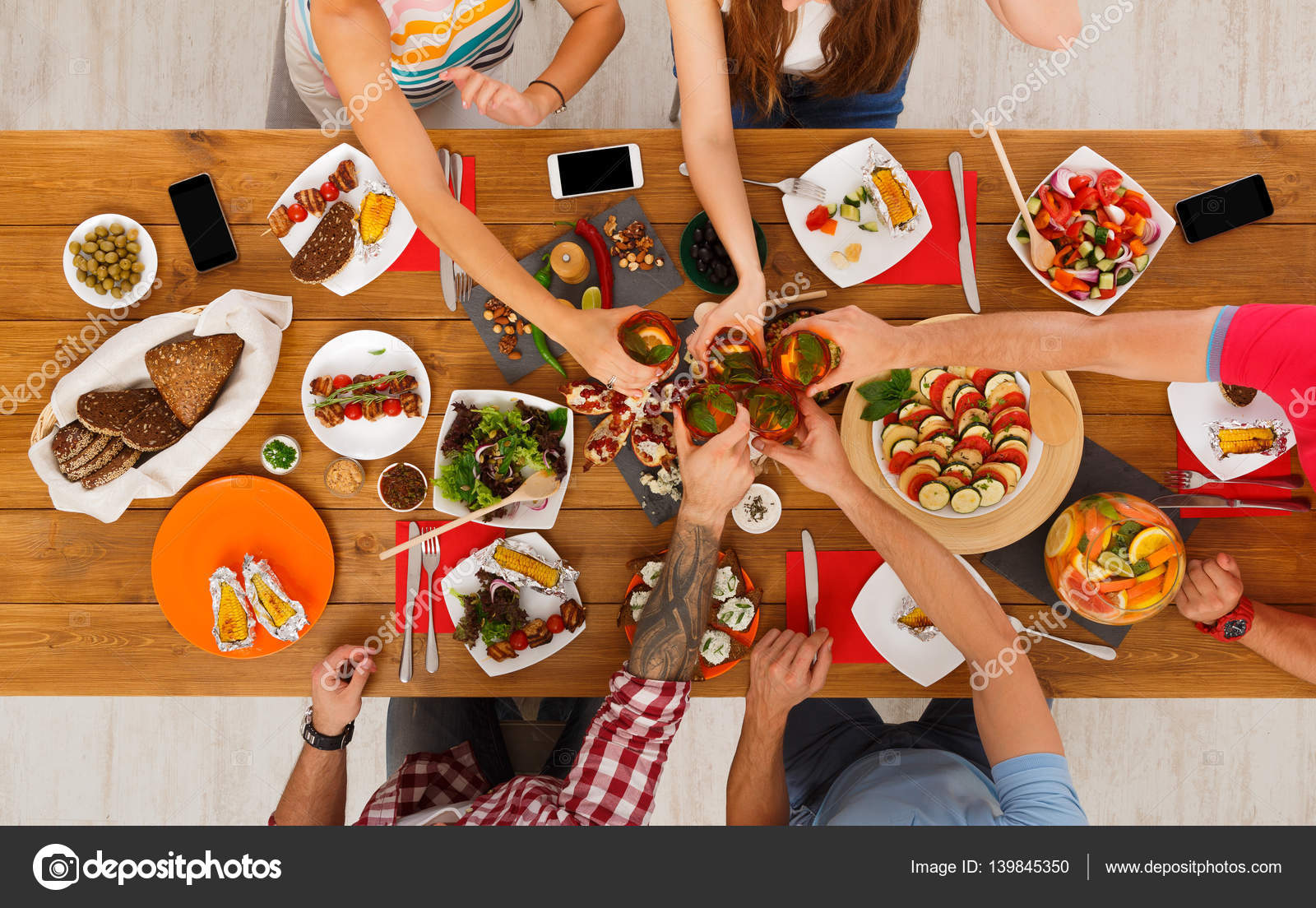 People say cheers clink glasses at festive table dinner party Stock