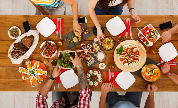 Mensen eten gezonde maaltijden op feestelijke tabel diner — Stockfoto