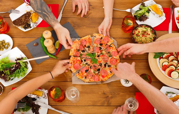 Mensen eten pizza op tafel feestelijk diner — Stockfoto