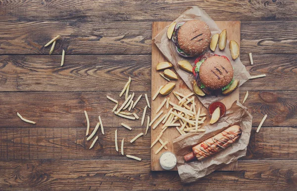Fast food yukarıdan ahşap üzerine. Hamburger, sosisli ve patates