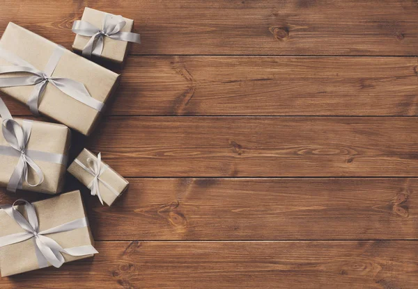 Geschenke in Geschenkboxen auf Holzrahmen Hintergrund — Stockfoto