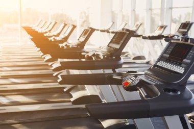 Modern bir spor salonu iç donanımları, kardiyo egzersizi için koşu bandı kontrol panelleri