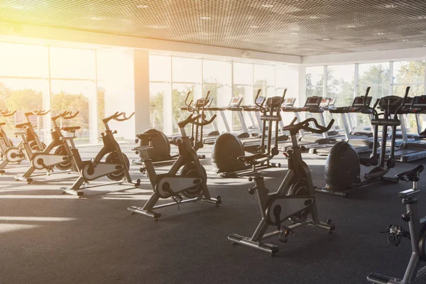 Interior moderno del gimnasio con el equipo, bicicletas de ejercicio de fitness —  Fotos de Stock