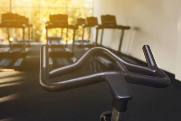 Modern gym interior with equipment, fitness exercise bike handlebar — Stock Photo, Image