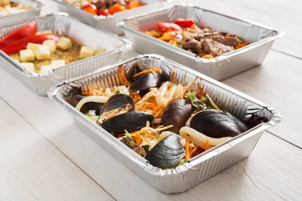 Healthy food take away in foil box at wood background