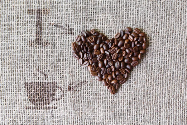 Любовь к кофе - фактура бурлапа с формой сердца фасоли — стоковое фото
