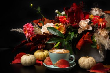 Siyah arka plan üzerine cappuccino kahve ve çiçek kompozisyon