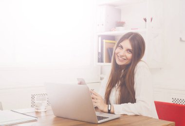 Ofis büro dizüstü bilgisayar ile başına oturmuş güzel genç iş kadını