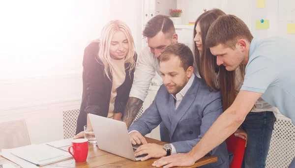 Les gens d'affaires heureux équipe ensemble près d'un ordinateur portable dans le bureau — Photo