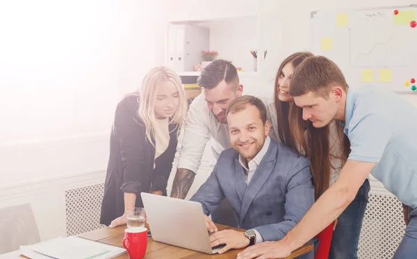 Gente de negocios feliz se unen cerca de la computadora portátil en la oficina — Foto de Stock