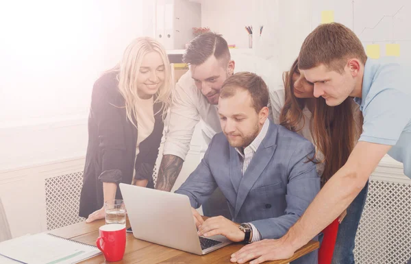 Gente de negocios feliz se unen cerca de la computadora portátil en la oficina — Foto de Stock