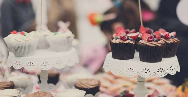 Hermosos cupcakes con bayas de primer plano en la mesa del banquete . — Foto de Stock