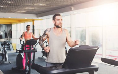 Koşu bandında koşmak spor salonunda genç adam