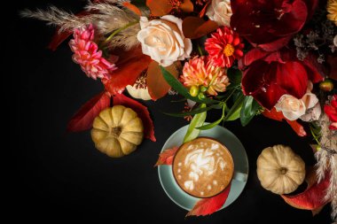 Siyah arka plan üzerine cappuccino kahve ve çiçek kompozisyon