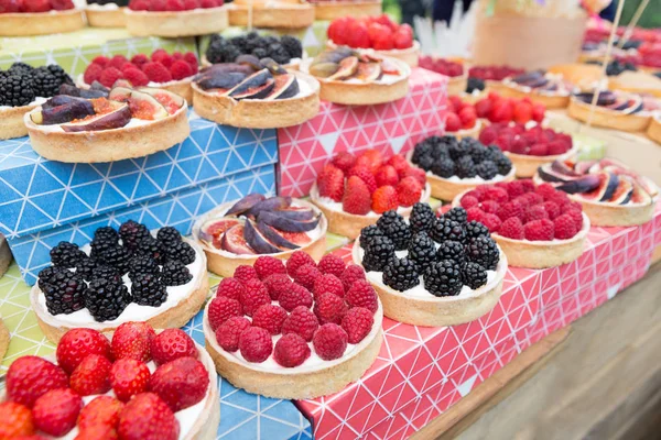 Fruit and berry tarts dessert tray assorted outdoors