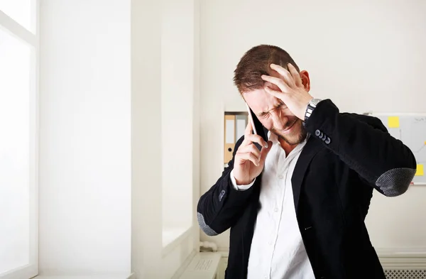 Ung stressad affärsman samtal mobiltelefon i moderna kontor — Stockfoto
