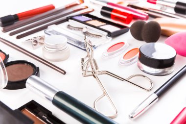 Makyaj kozmetik araçları ve temel özellikleri, düz beyaz arka plan üzerinde yatıyordu