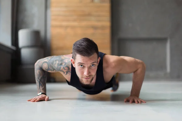 Young man fitness workout, push ups or plank