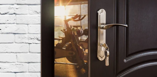 在打开的门，与健身自行车健身会所健身房入口 — 图库照片