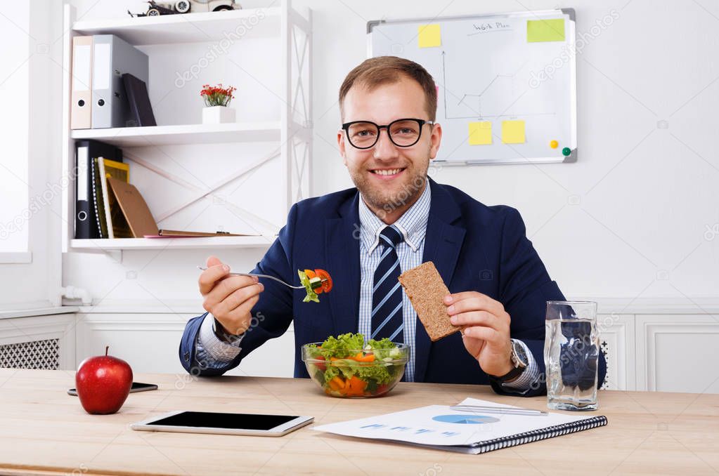 Man has healthy business lunch in modern office interior