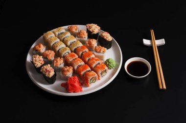 Somon suşi ve siyah arka plan, üstten görünüm üzerinde rulo