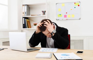 Genç işadamı modern beyaz ofis içinde laptop ile konsantre