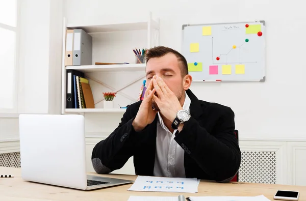 Young benadrukt zakenman met laptop in moderne witte kantoor — Stockfoto