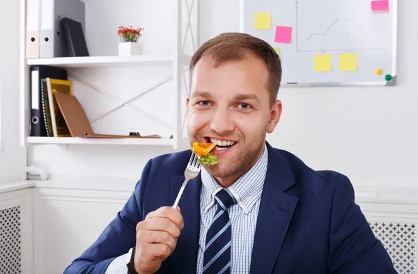 Человек ест здоровый деловой обед в современном интерьере офиса — стоковое фото