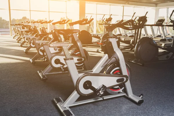 Modern gym interior with equipment, fitness exercise bikes