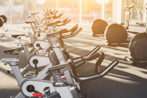 Modern gym interior with equipment, fitness exercise bikes