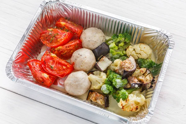 Healthy food take away in foil box closeup