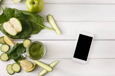 Yeşil smoothie maddeler, beyaz cep telefonu ile üstten görünüm Detoks