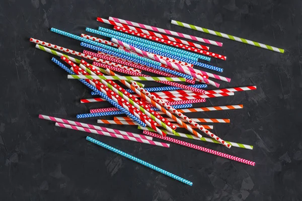 Colorful striped cocktail straws on blackboard texture surface, abstract background — Stock Photo, Image