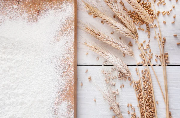 Bakning koncept på vit trä bakgrund, strödde mjöl med kopia utrymme — Stockfoto