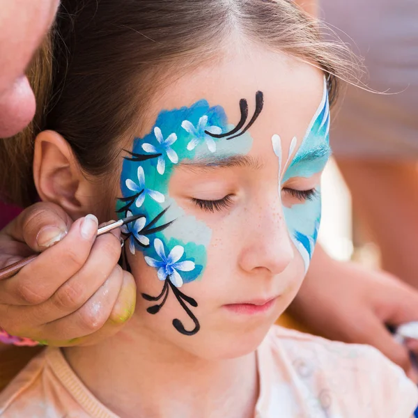 Pintura de cara de niño femenino, proceso de mariposa —  Fotos de Stock