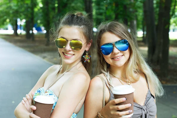 Twee mooie jonge boho meisjes hebben koffie in park — Stockfoto