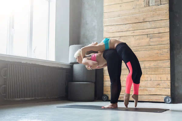 Mujer con instructor de yoga en clase, estiramiento de espalda —  Fotos de Stock