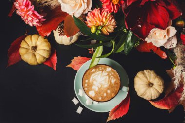 Siyah arka plan üzerine cappuccino kahve ve çiçek kompozisyon