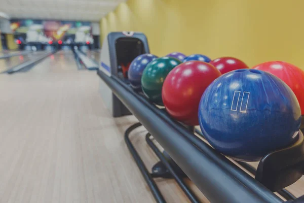 Bowling balls return machine, alley background