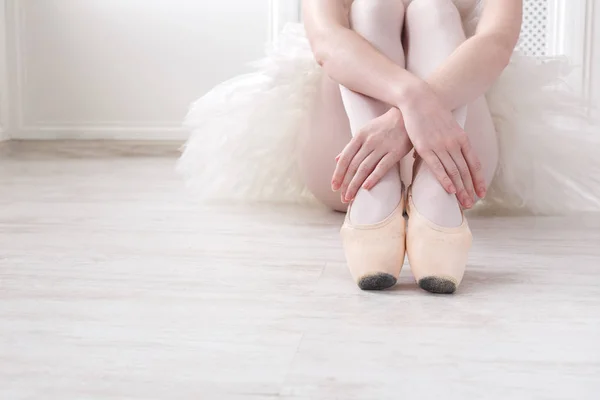 Bailarina coloca em sapatos de balé pointe, pernas graciosas — Fotografia de Stock