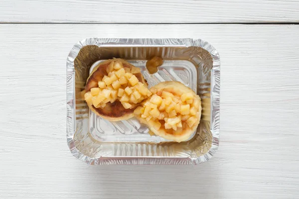 Healthy food in foil box, diet concept. Apple dessert