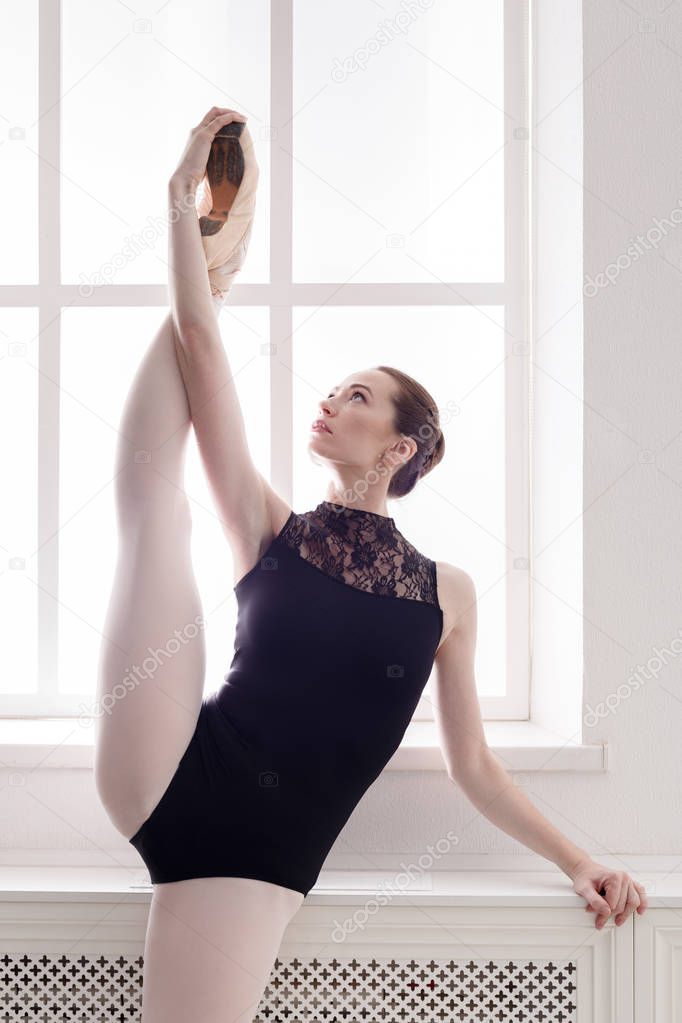Classical Ballet dancer in split stretching, portrait