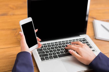 Dizüstü bilgisayar ve akıllı telefon kullanan kadın Close-Up