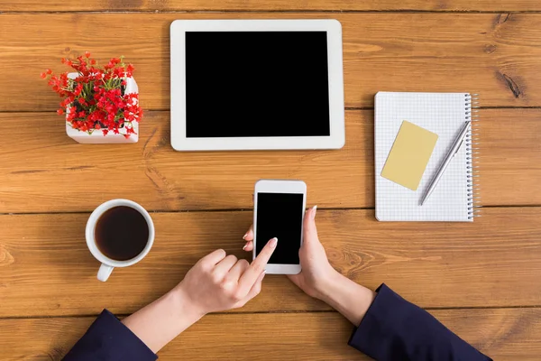 Vista superior de primer plano de la mujer utilizando el teléfono en el lugar de trabajo — Foto de Stock