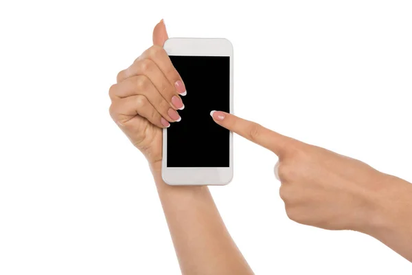 Женские руки, указывающие на чистый экран мобильного телефона — стоковое фото
