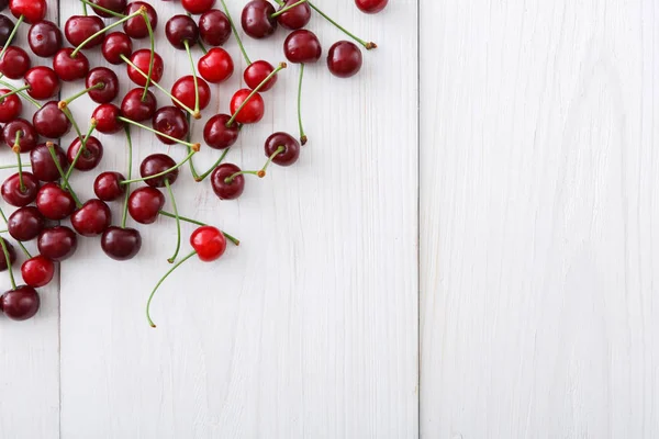 Cerezas dulces frescas sobre fondo de madera blanca — Foto de Stock