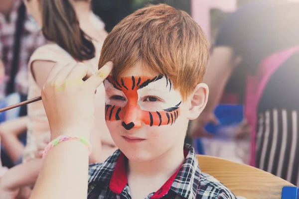 Kind jongen gezicht schilderen, tijger ogen besluitvormingsproces — Stockfoto